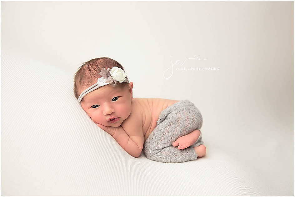 Newborn Girl open eyes in pose