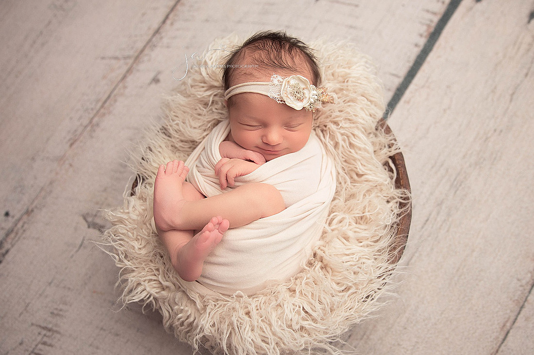 Newborn Baby Girl Wrapped in Neutrals Smiling
