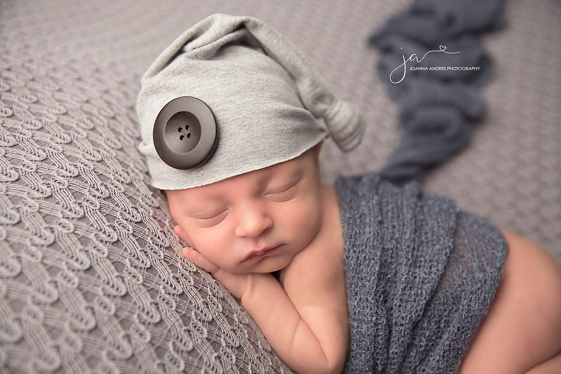 Baby Jordan Sleeping wearing gray, black and red striped pants. 