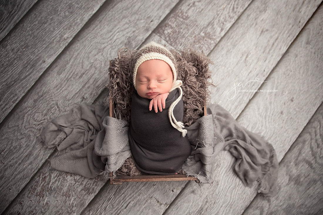Baby Jordan Sleeping wearing gray, black and red striped pants. 