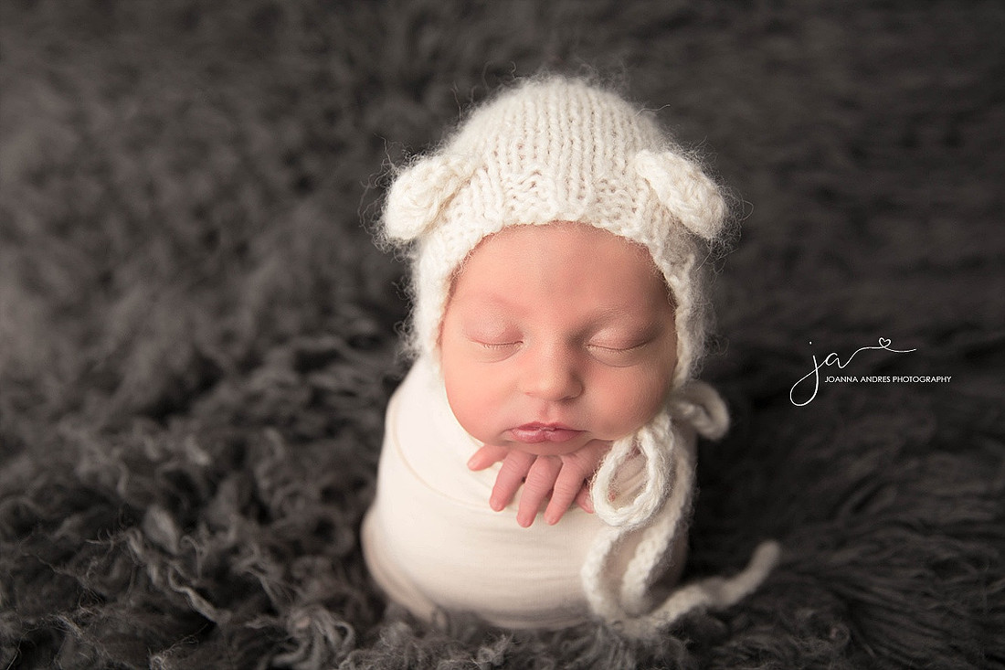 Baby Jordan Sleeping wearing gray, black and red striped pants. 