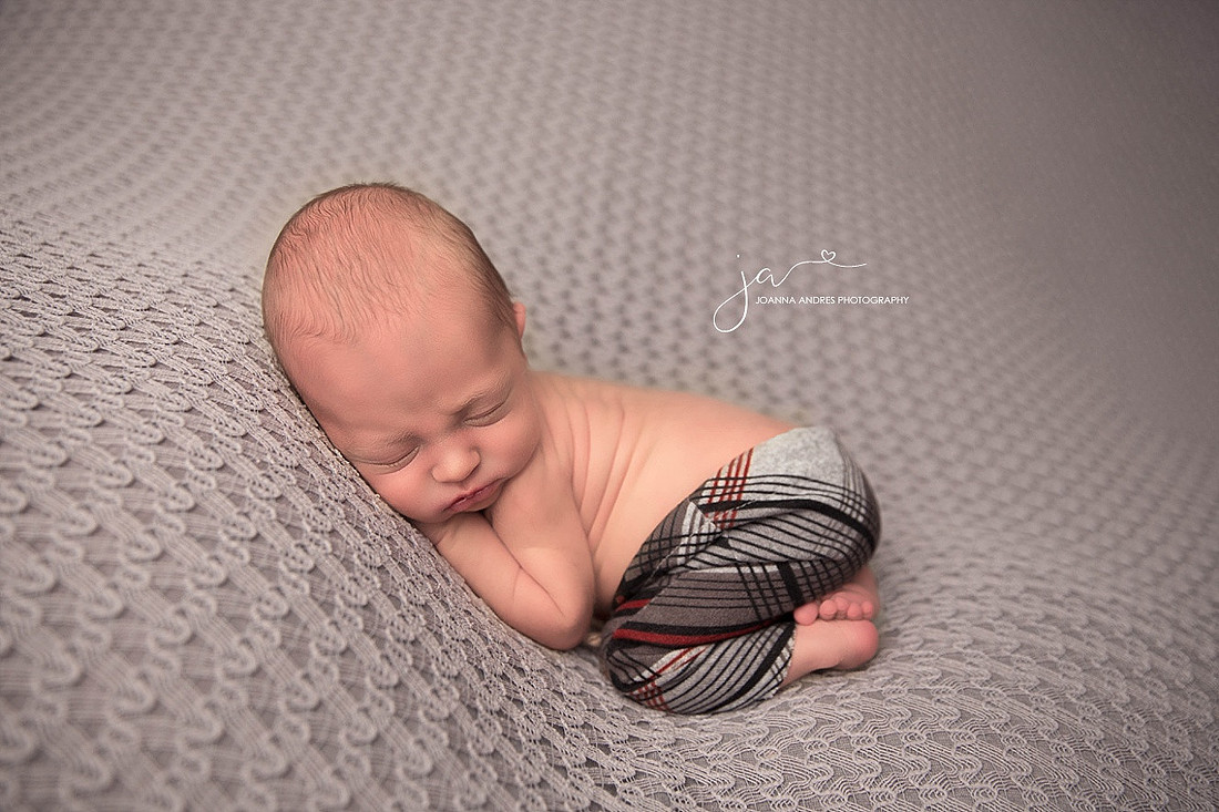 Baby Jordan Sleeping wearing gray, black and red striped pants. 