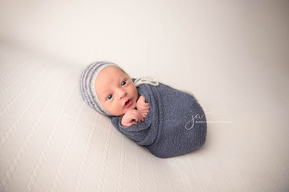 Baby Jordan Sleeping wearing gray, black and red striped pants. 