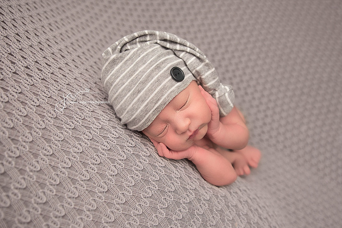 Newborn Baby Boy with hands on cheeks