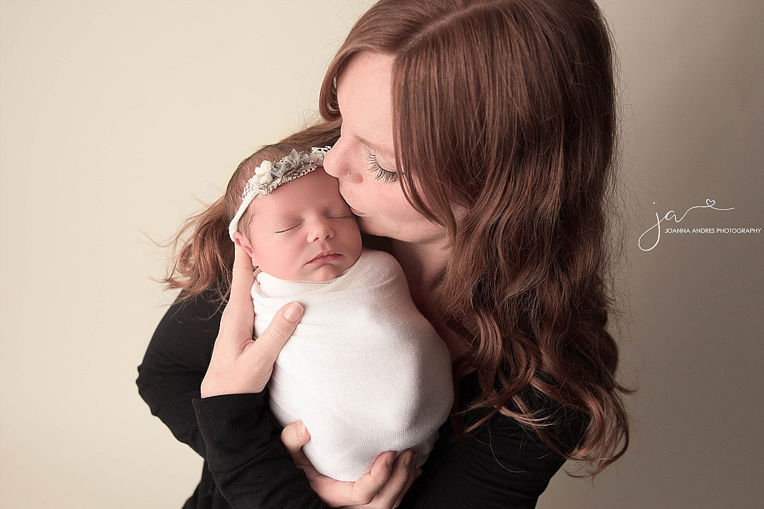 Mom holding and kissing Baby girl