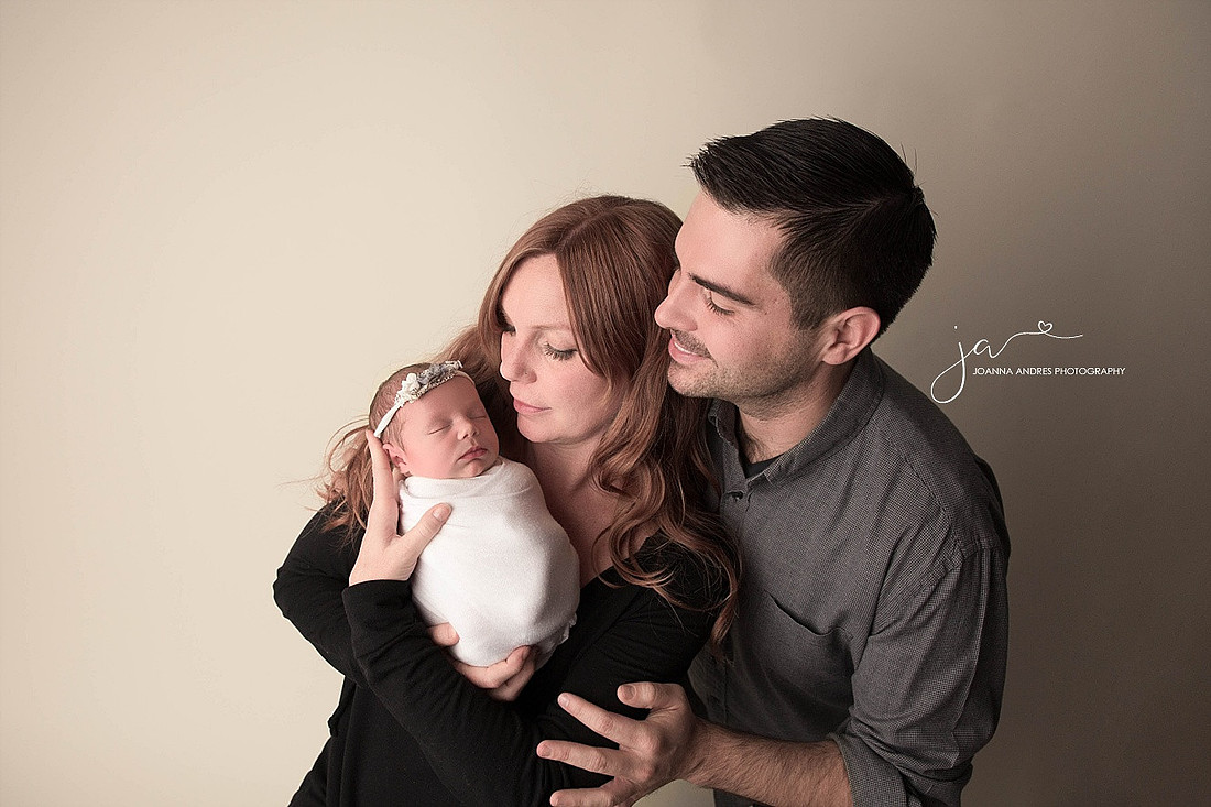 Parents looking at their newborn baby girl