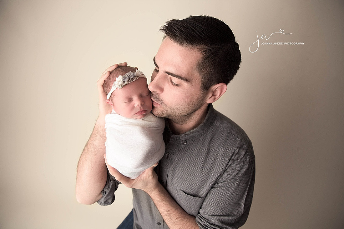 Dad holding and kissing his baby girl