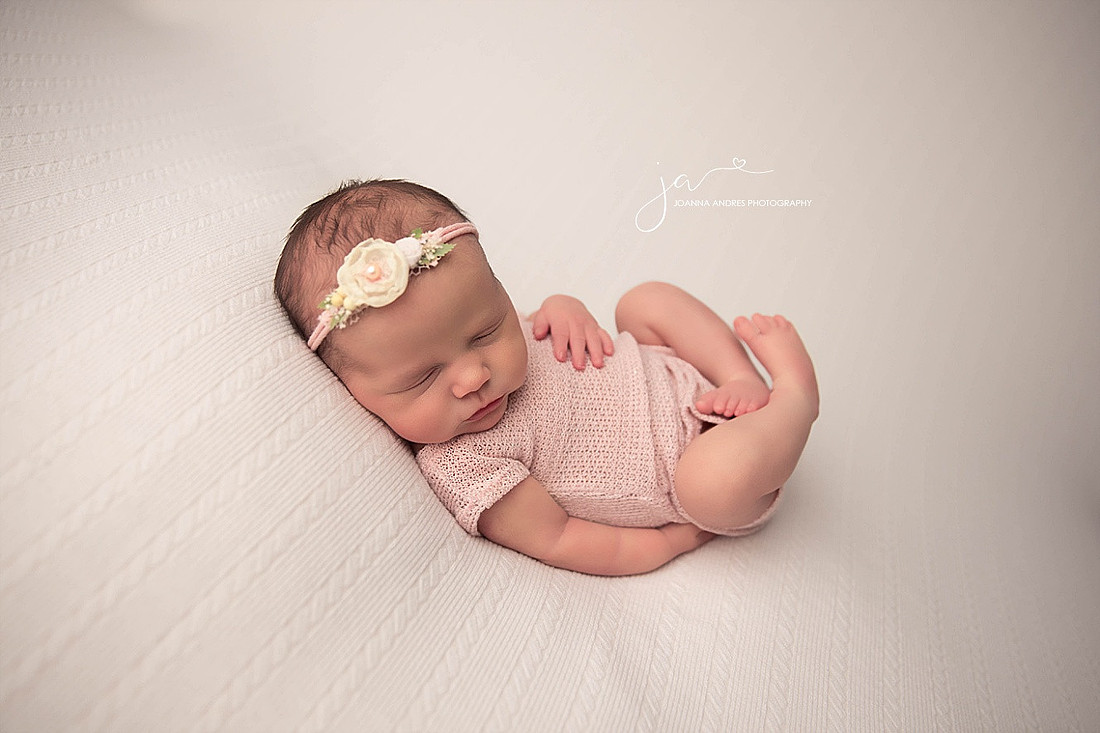 Newborn Baby Girl curled up in Pinks