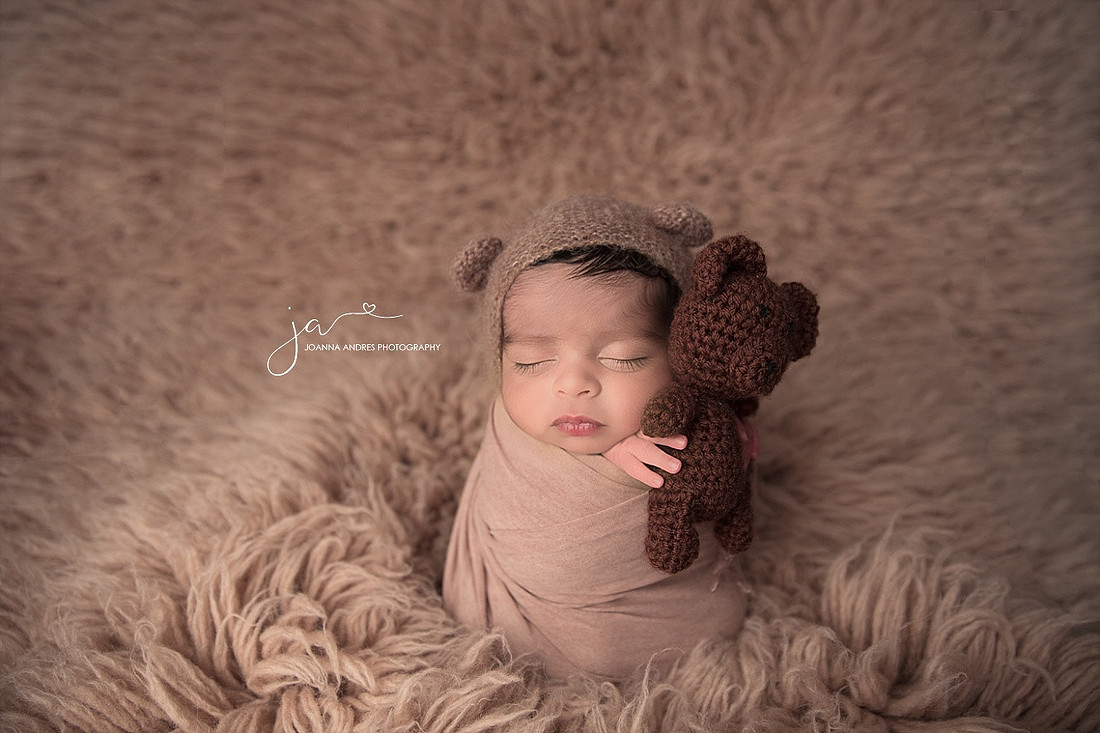 Baby Boy holding a tiny little teddy bear