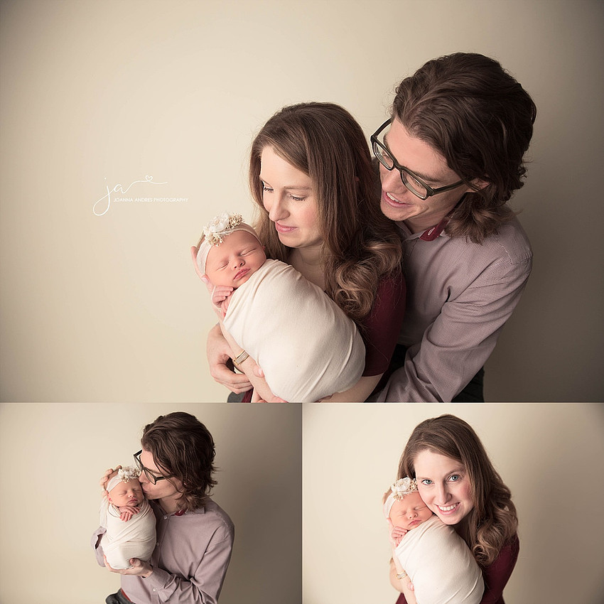 Newborn baby girl wrapped with parents holding her.