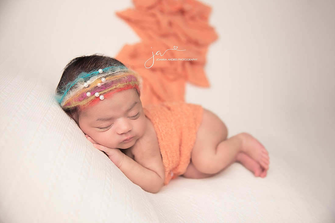 Baby Girl with Rainbow Headband and Orange Wrap Draped on her