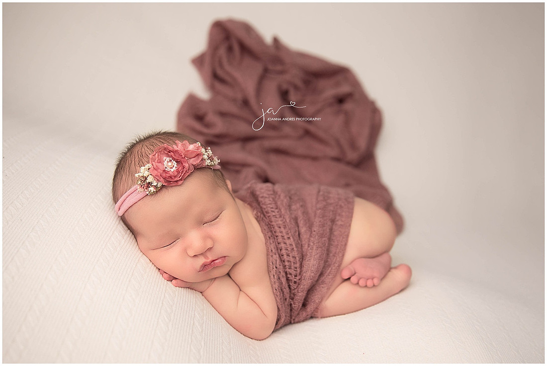 Newborn Baby Girl with Mauve colored blanket and headband