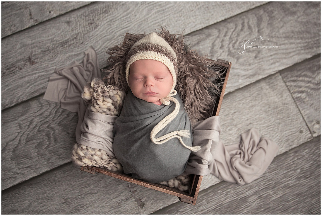 Newborn Baby Boy in Crate wrapped in Grays