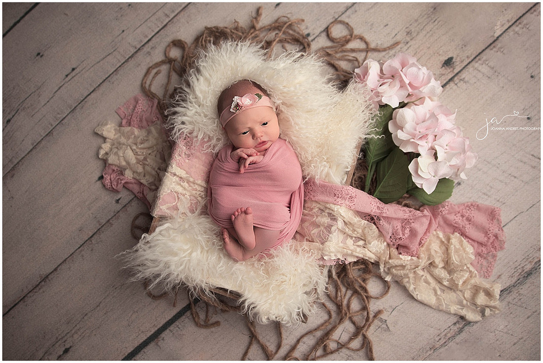 Baby Girl wrapped in pinks in a basket