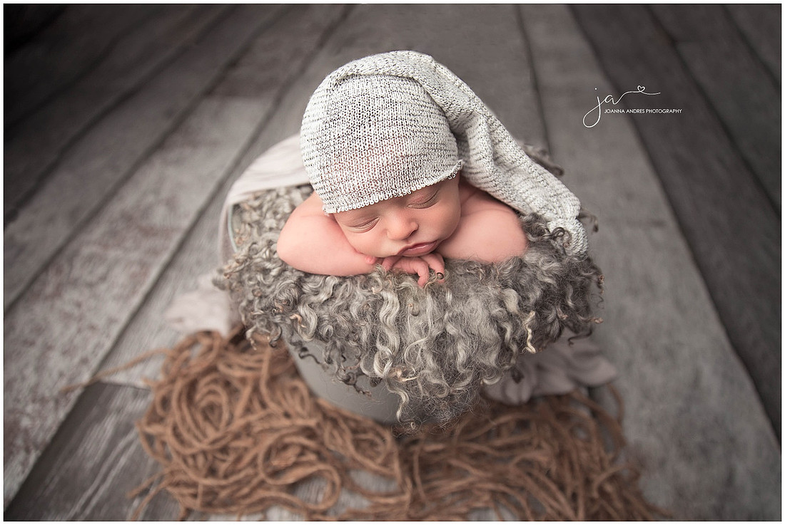Baby In a Gray Bucket with a gray hat
