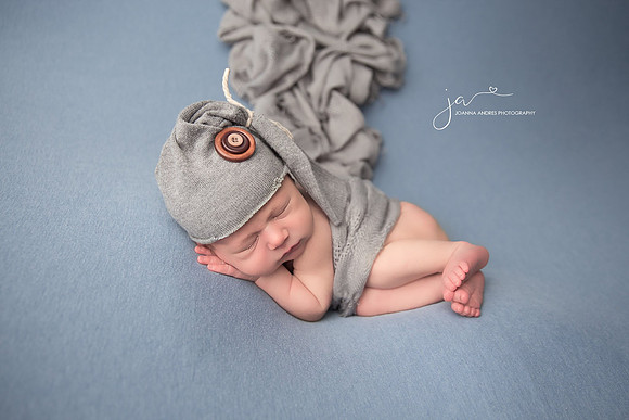 Side Laying Pose Newborn Boy with Gray wrap and gray hat