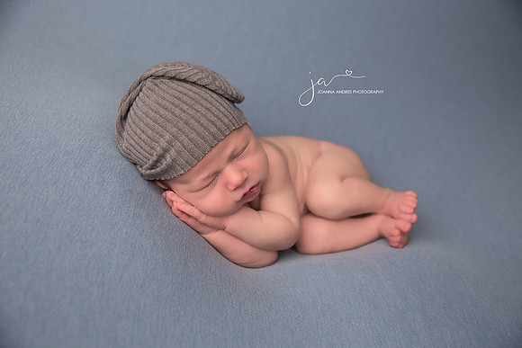 Baby Boy with Gray hat side laying pose and blue blanket