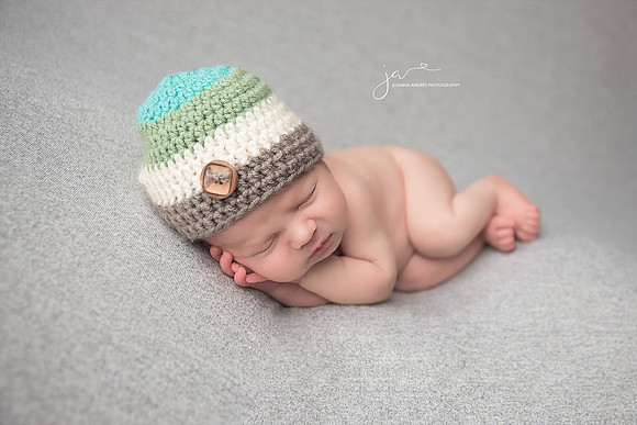 NEwborn Baby Boy Side Laying Pose with Gray, White, Green and Teal hat