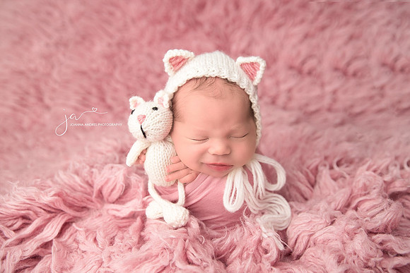 Baby Girl wrapped in Pnk Holding a kitty Stuffy