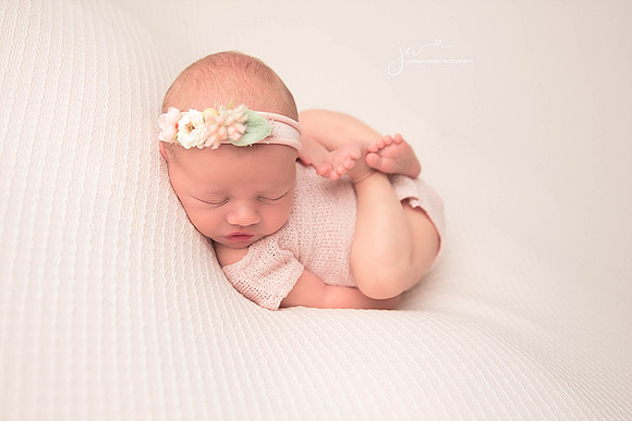 Huck FInn Pose baby girl with neutral backdrop and pink outfit