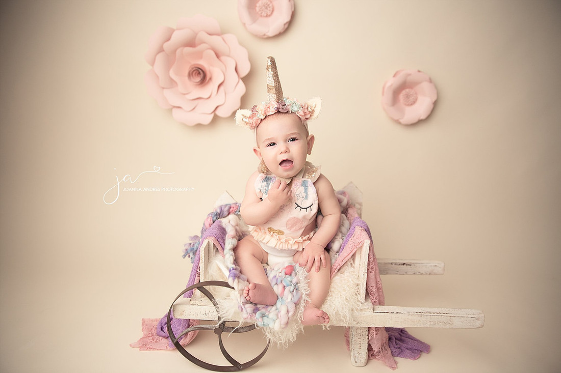 Baby in unicorn outfit on wagon