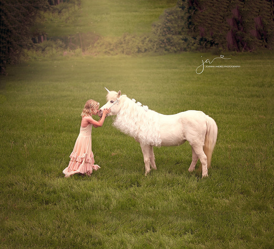 Little Girl in Pink Dress Kissing Unicorn