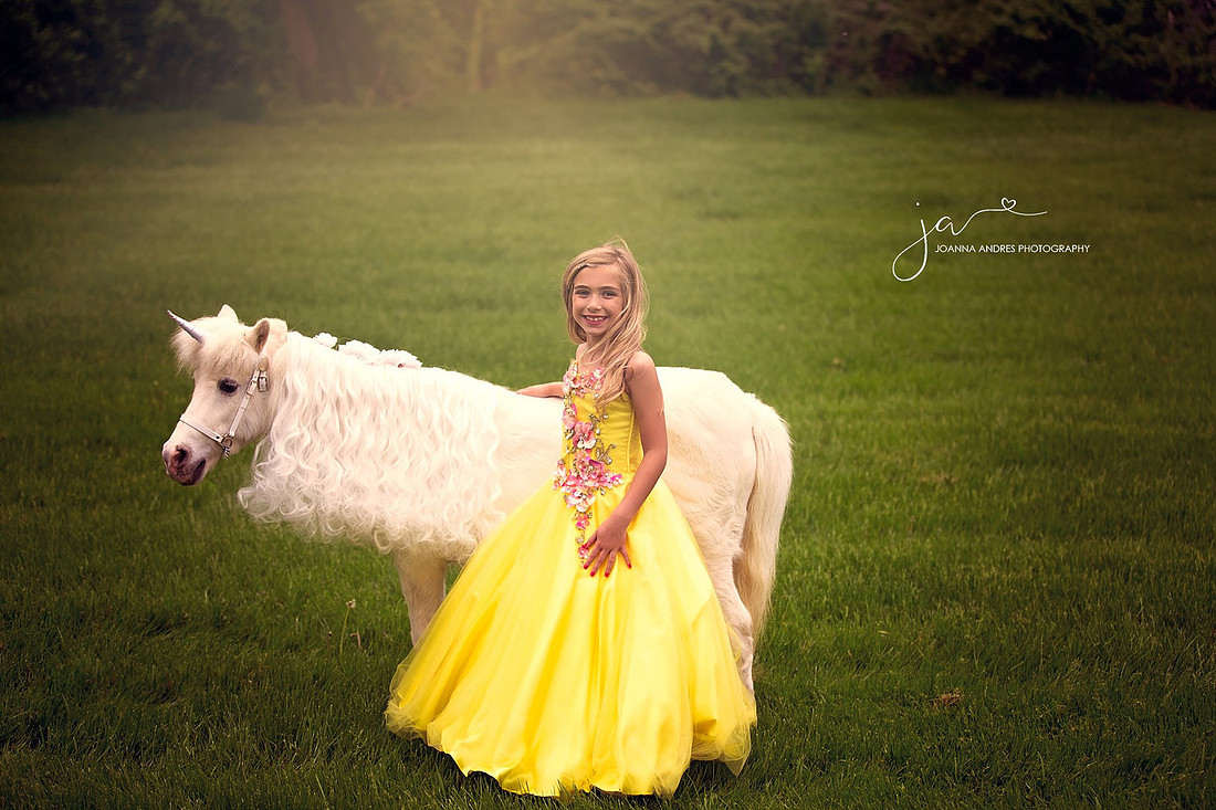 Unicorn and little girl in yellow dress