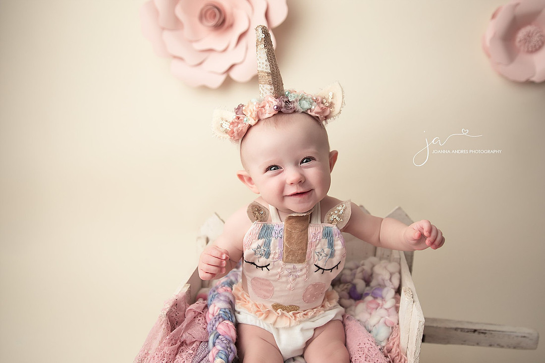 Baby dressed as a unicorn smiling