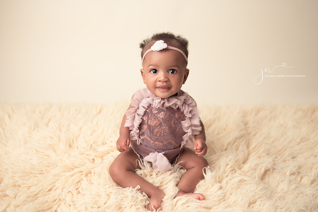 Baby in purpler romper sitting up