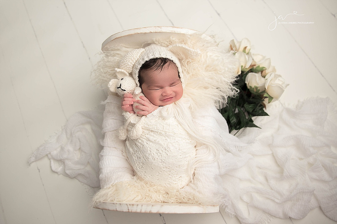 Baby in whites smiling