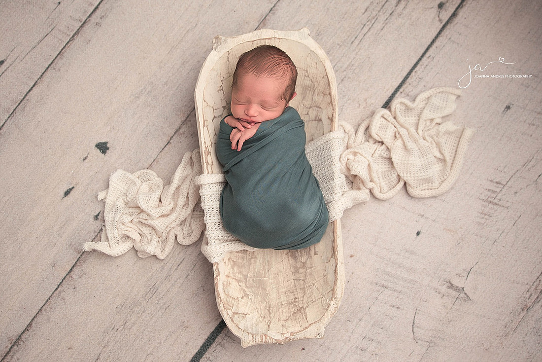 Baby Boy in a a white prop wrapped in blue