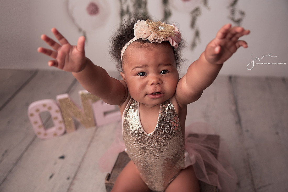 Baby girl holding her arms out