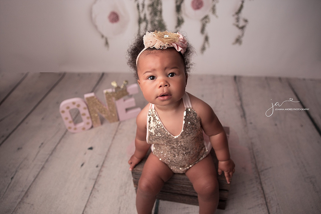 Baby Girl in gold sequence and pink tulle looking at the camera