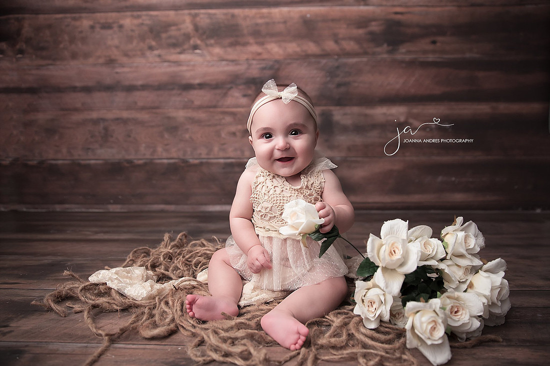 Baby Girl in Neutral Lace Outfit holding rose