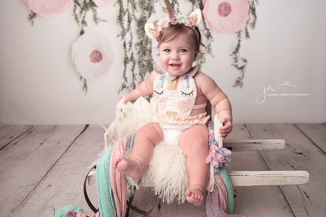 Baby smilng in unicorn outfit