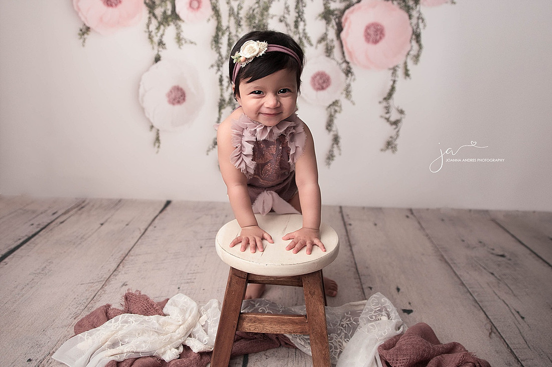Baby leaning on a stool