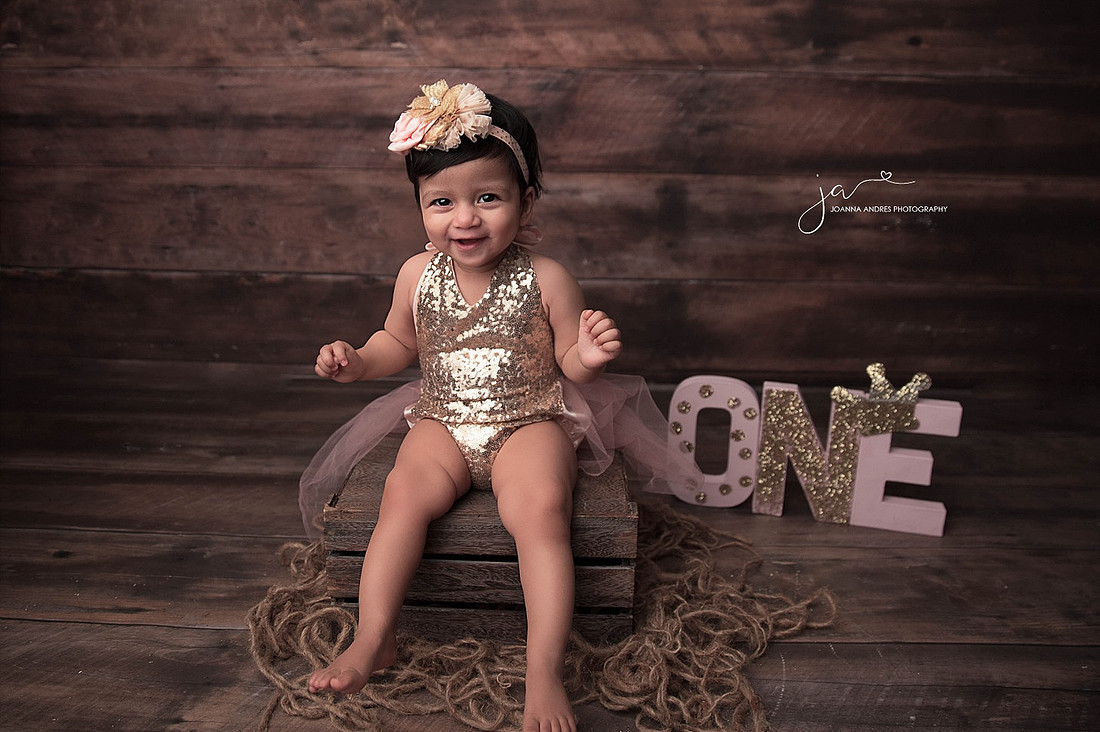 Baby in pink sequince sitting on prop