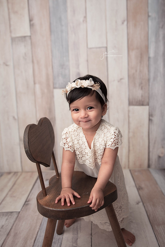 Baby leaning on chair