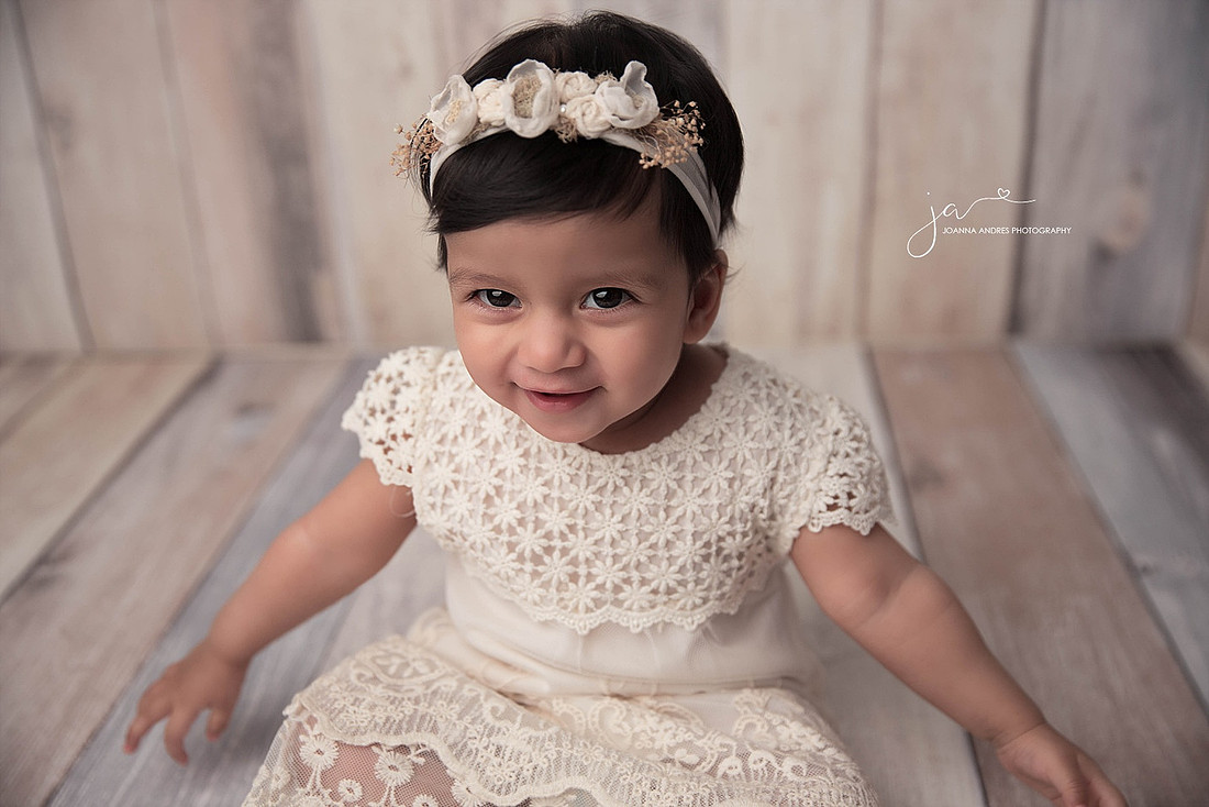 Baby smiling with cream dress
