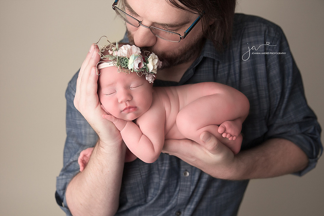 Dad holding and kissing his baby girl