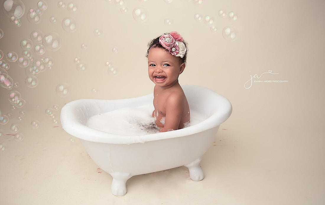 Baby Girl smiing with Bathub and Bubbles.