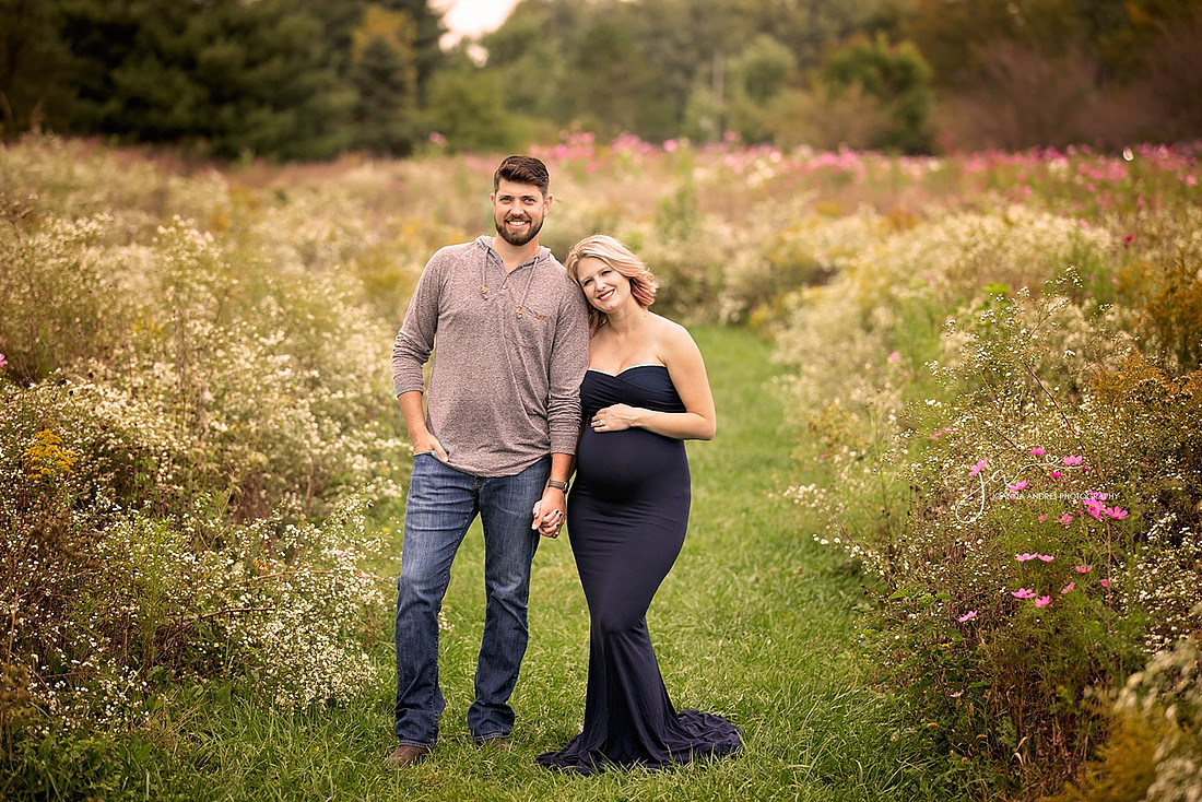Maternity Photographer with Couple in a field of wild flowers