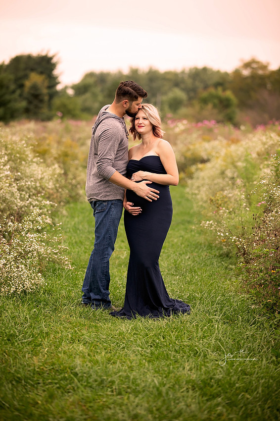 Husband Kissing pregnant wife on forehead"