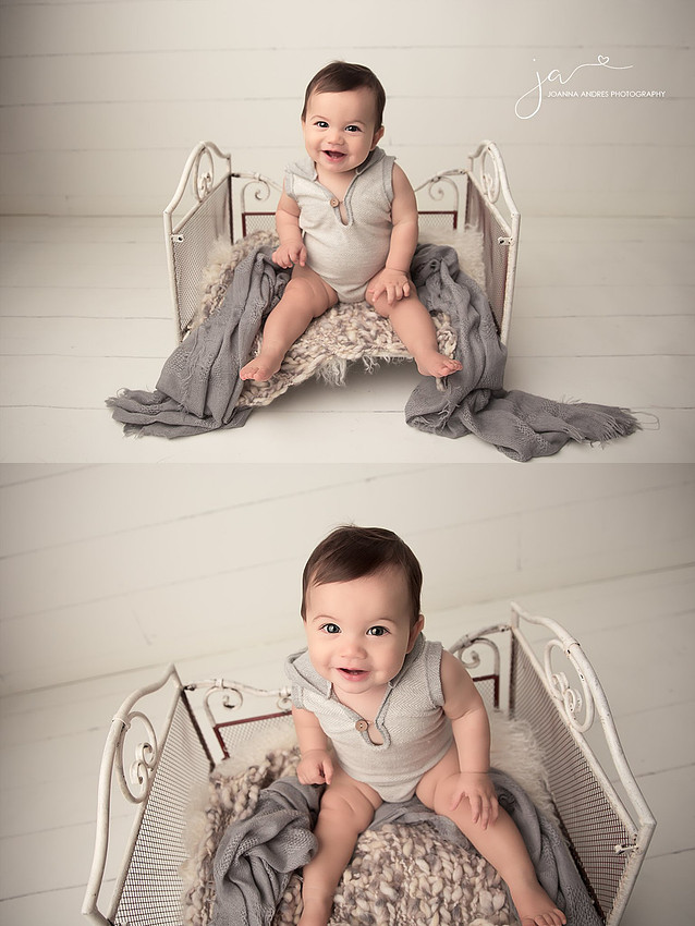 Baby Boy in Grays sitting on a bed
