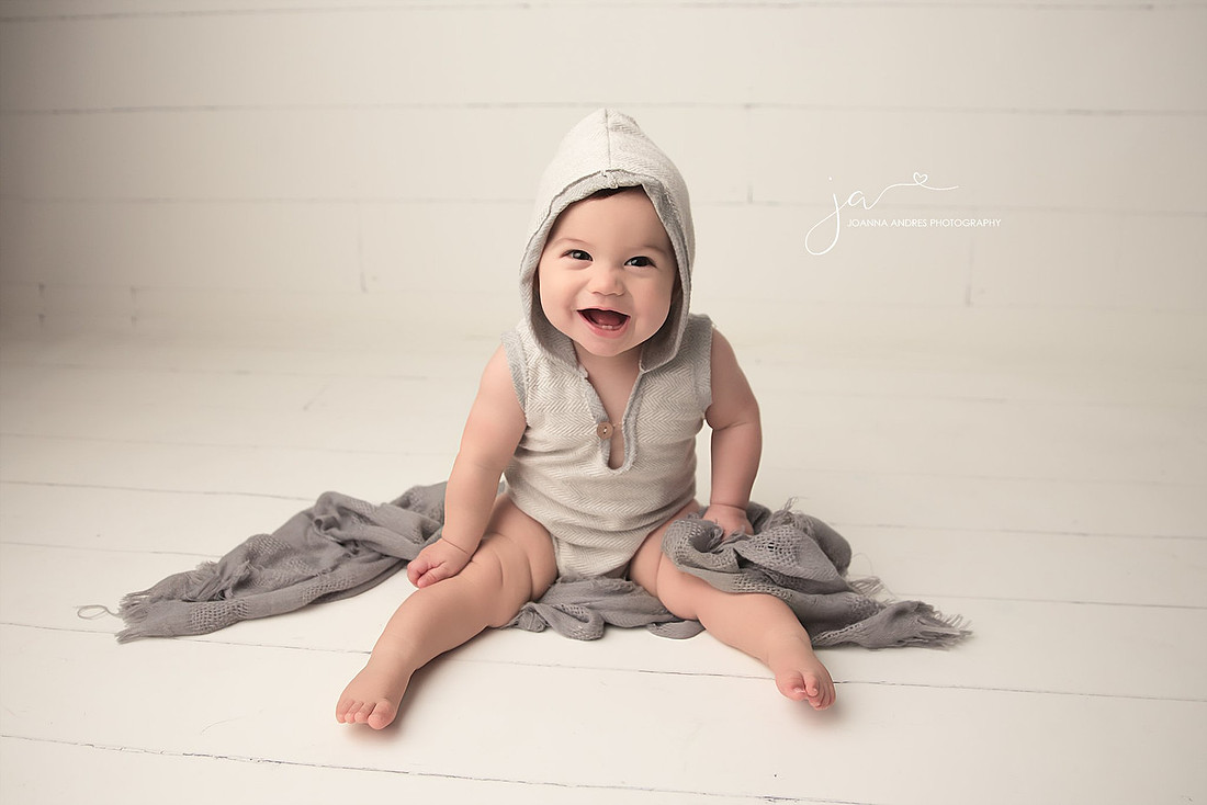 Baby Boy Smilng with Gray outfit and hoodie on