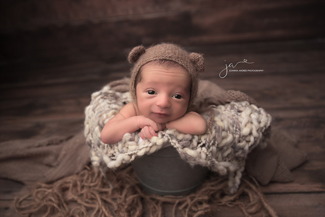 Baby BOy in a bucket wide eyed